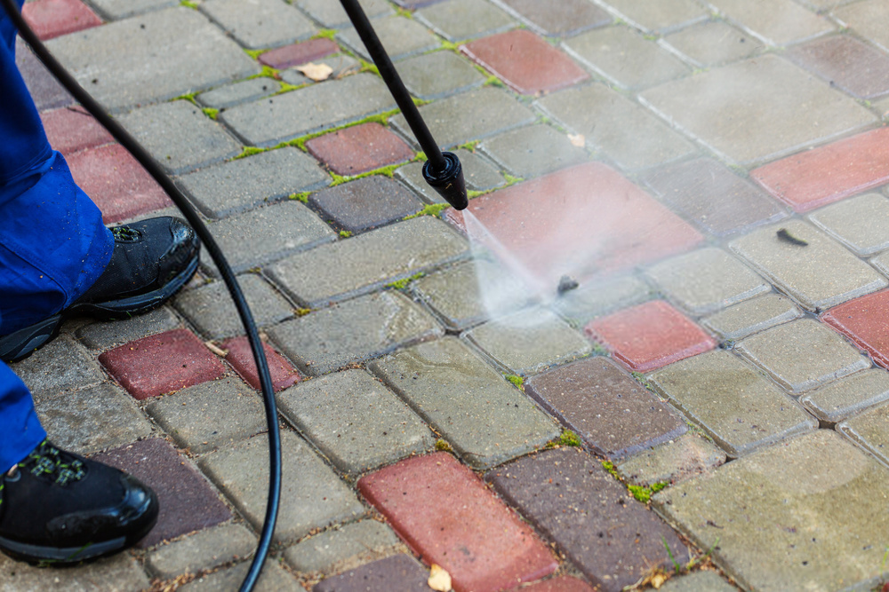 Pressure washing dirt and algae off brick paving